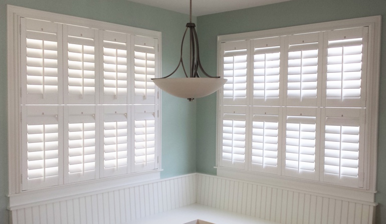 Pastel green wall in Houston kitchen with shutters.